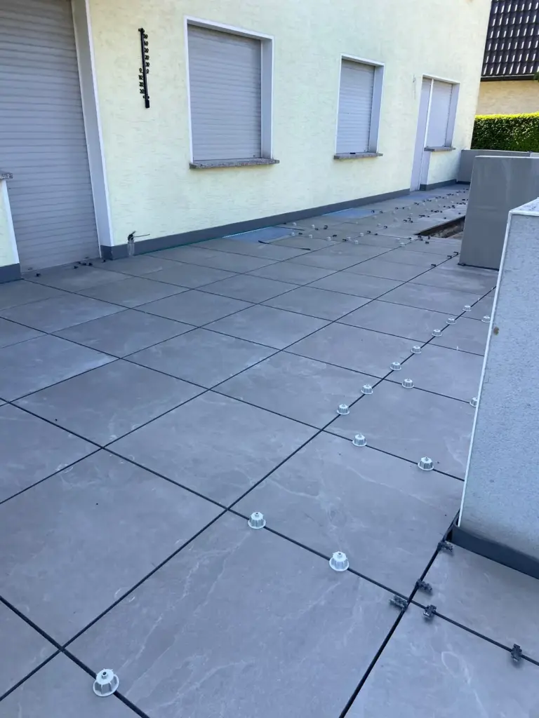 Terrasse aus großen grauen Platten während der Verlegung